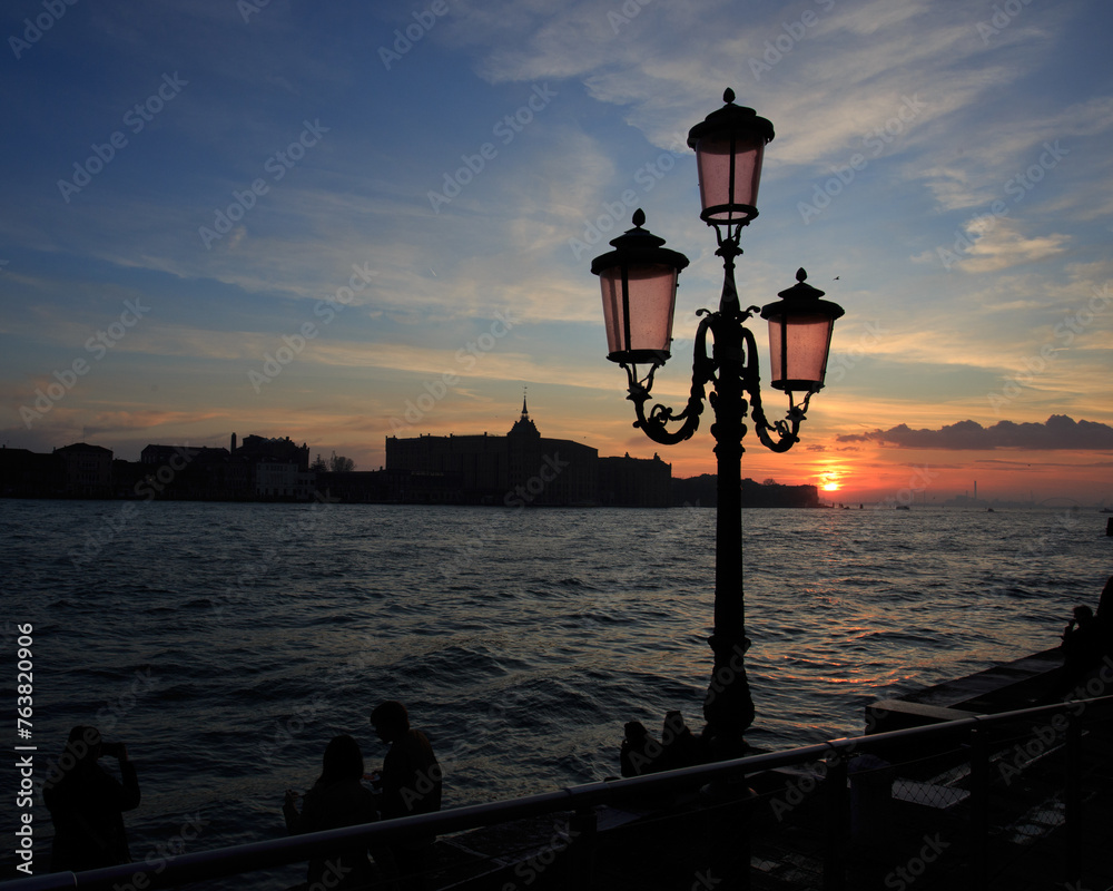 Lamppost at the water's edge in Venice.