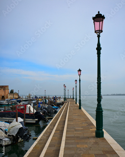 Scenic view of Burano fishing harbor with colorful boats and a pier. © Wirestock