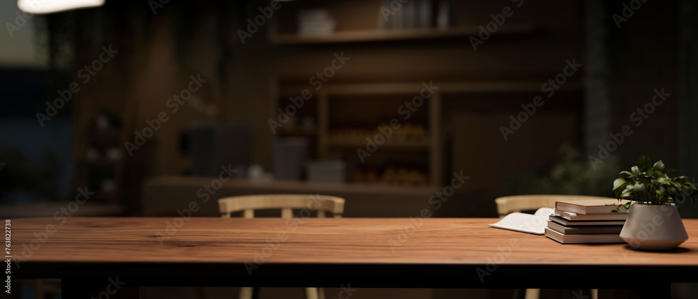 A presentation space on a rustic wooden desk in a dark neutral contemporary home office at night.