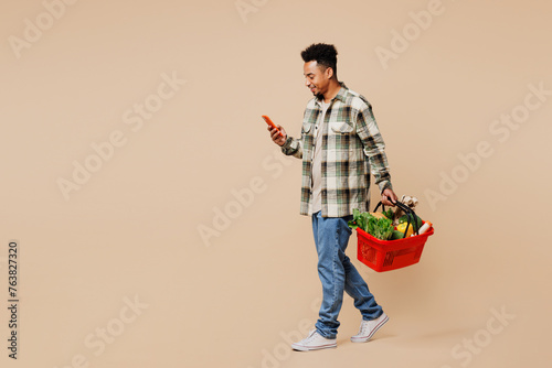 Bild auf Leinwand Full body smiling side view young man wear grey shirt hold red basket bag with f
