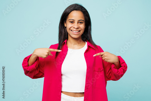 Little kid teen girl of African American ethnicity wear pink shirt white t-shirt point index finger on herself isolated on plain pastel light blue cyan background studio. Childhood lifestyle concept.
