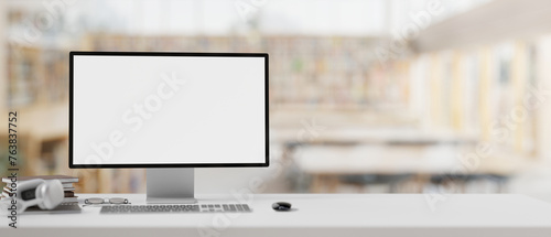 A white-screen computer mockup on a table with a blurred background of a contemporary library.