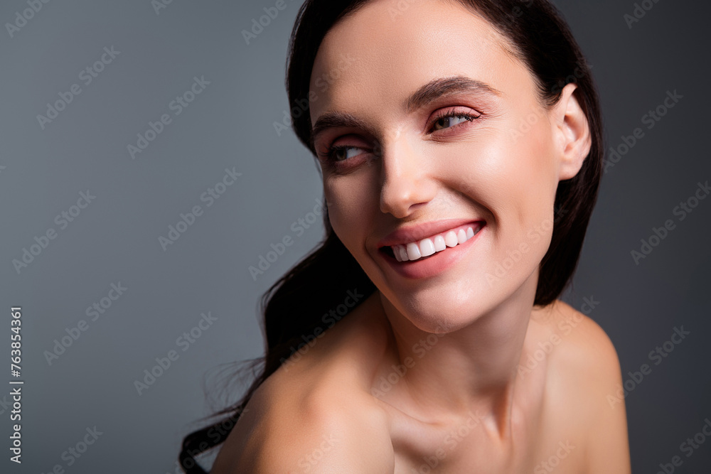 Photo of joyful smiling woman with brunette curls lokk empty space isolated grey color background Photo of joyful smiling woman with brunette curls lokk empty space isolated grey color background