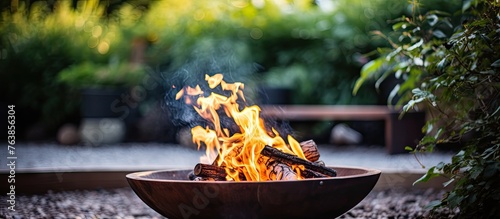 Fire pit with burning flames in a gravel area