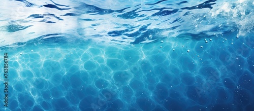 A close up of a wave in the ocean with blue water