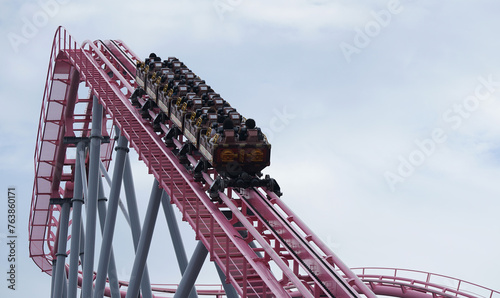 The sight of an amusement park with a roller coaster rising in the sky photo