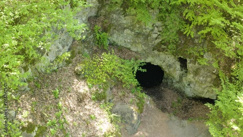 Pedestal drone shot moving above the opening of a cave known as the site for the tomb of Egyptian goddess Bastet, located up the mountains of Strandzha in Bulgaria. photo