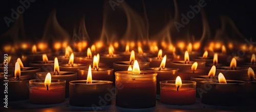 Row of lit candles in a dark room