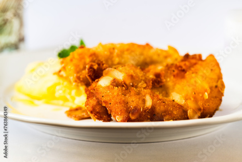 Fried schnitzel in breadcrumb with almonds, mashed potato.