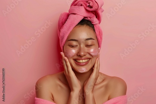 Happy beautiful asian american young woman touching facial skin, looking away with perfect toothy smile, laughing, enjoying beauty care, thinking on good skincare result