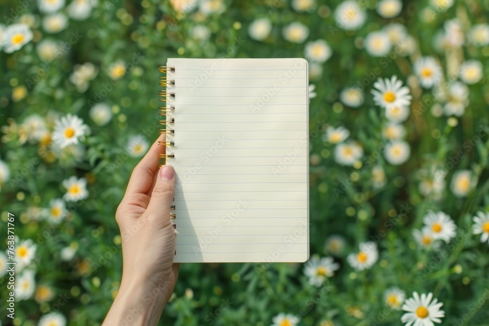 Close-up of hands holding an open, blank notebook against background Close-up of hands holding an open, blank notebook against background