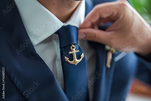 a man adjusting an anchor tie clip on his suit