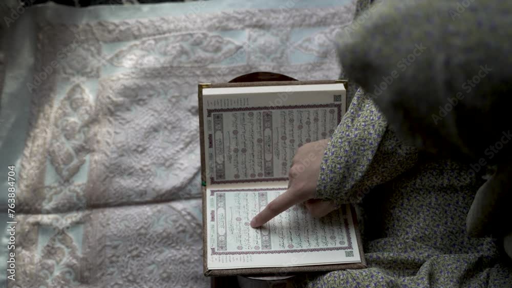 Woman Points Index Finger At Words While Reading Quran. - high angle shot