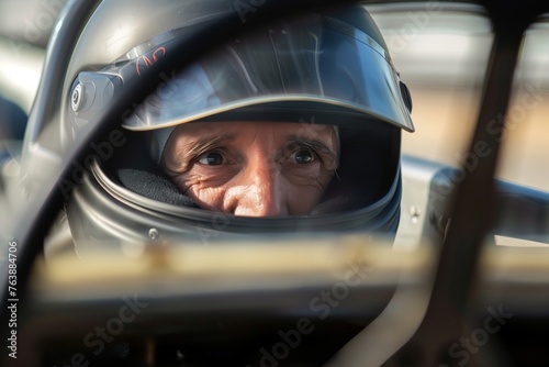 driver with focus on eyes visible through race car steering wheel © altitudevisual