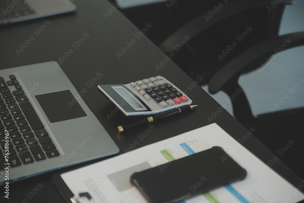 Laptop on a desk in an open financial office. Laptop on a desk in an open financial office.