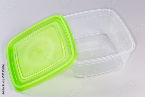 Empty plastic food storage container with removed green lid