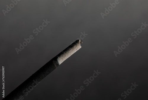 A closeup of a head of incense stick the grey textured background for graphic and web design use photo