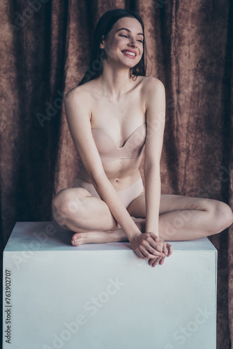 Photo no retouch of pretty joyful girl sitting platform advertise salon treatments isolated studio background