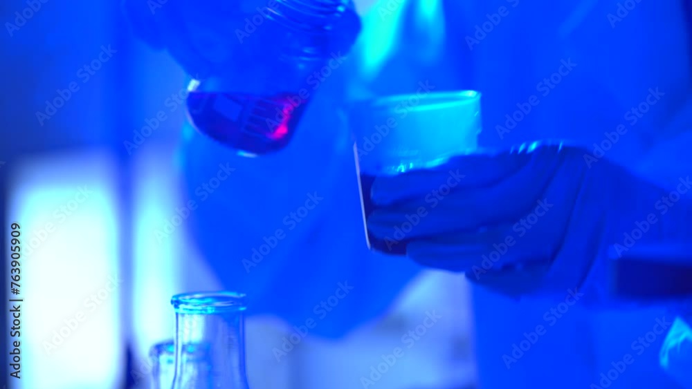 Life scientists researching in laboratory. Focused female life science professional pipetting solution into the glass cuvette. Healthcare and biotechnology concept. Life scientists researching in laboratory. Focused female life science professional pipetting solution into the glass cuvette. Healthcare and biotechnology concept.