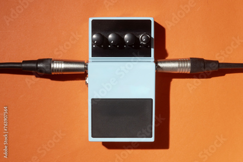 Light blue blank guitar pedal on orange background