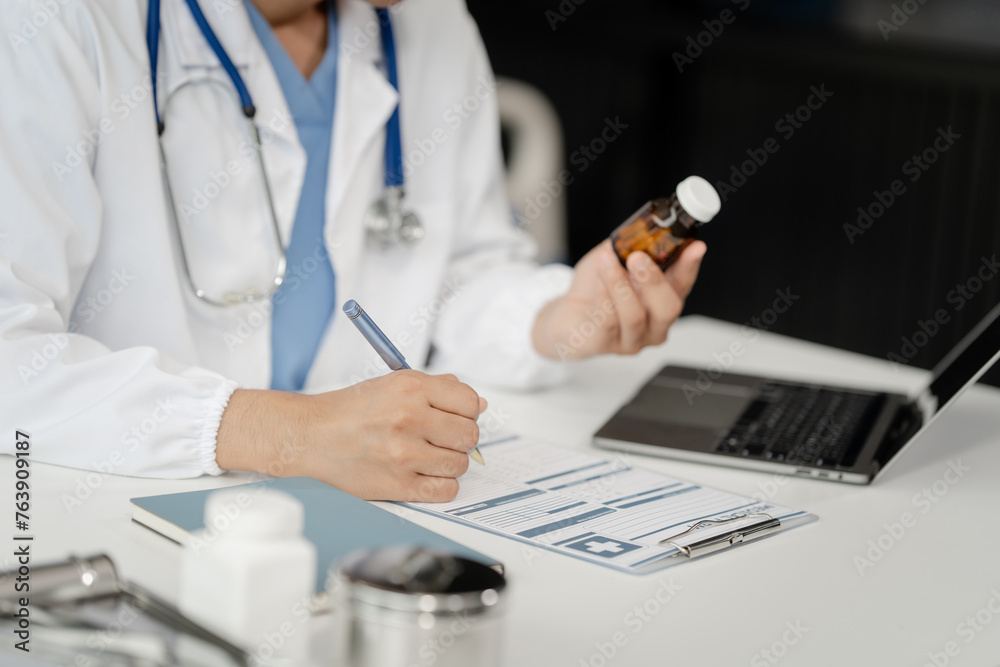 Portrait of Asian middle age male doctor in white lab coat and stethoscope while consult online in laptop via video conference. advice on good mental health management and medical treatment costs. Portrait of Asian middle age male doctor in white lab coat and stethoscope while consult online in laptop via video conference. advice on good mental health management and medical treatment costs.