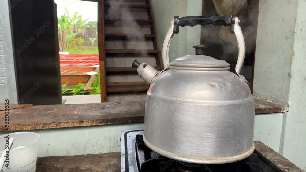 Boiling old steel silver kettle with a whistle with steam comes out. Boiling old steel silver kettle with a whistle with steam comes out.