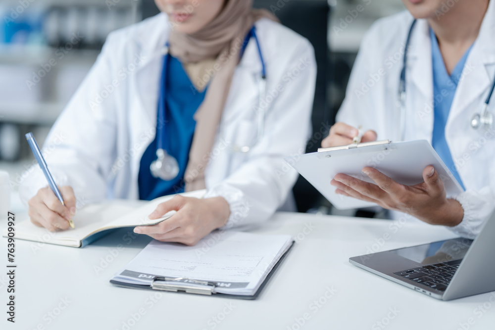 Medical team with nurses, Muslim people and Asian male doctors and specialists working together with laptops and tablets, support and wellness. listening for medical problems Medical team with nurses, Muslim people and Asian male doctors and specialists working together with laptops and tablets, support and wellness. listening for medical problems