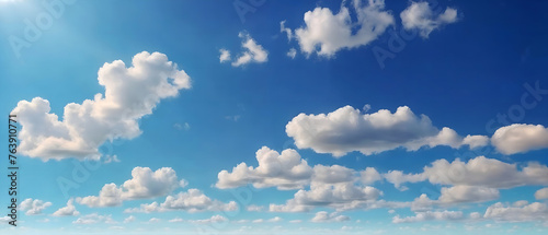 A wide view of a clear blue sky dotted with numerous white cumulus clouds  bathed in bright sunlight on a sunny day