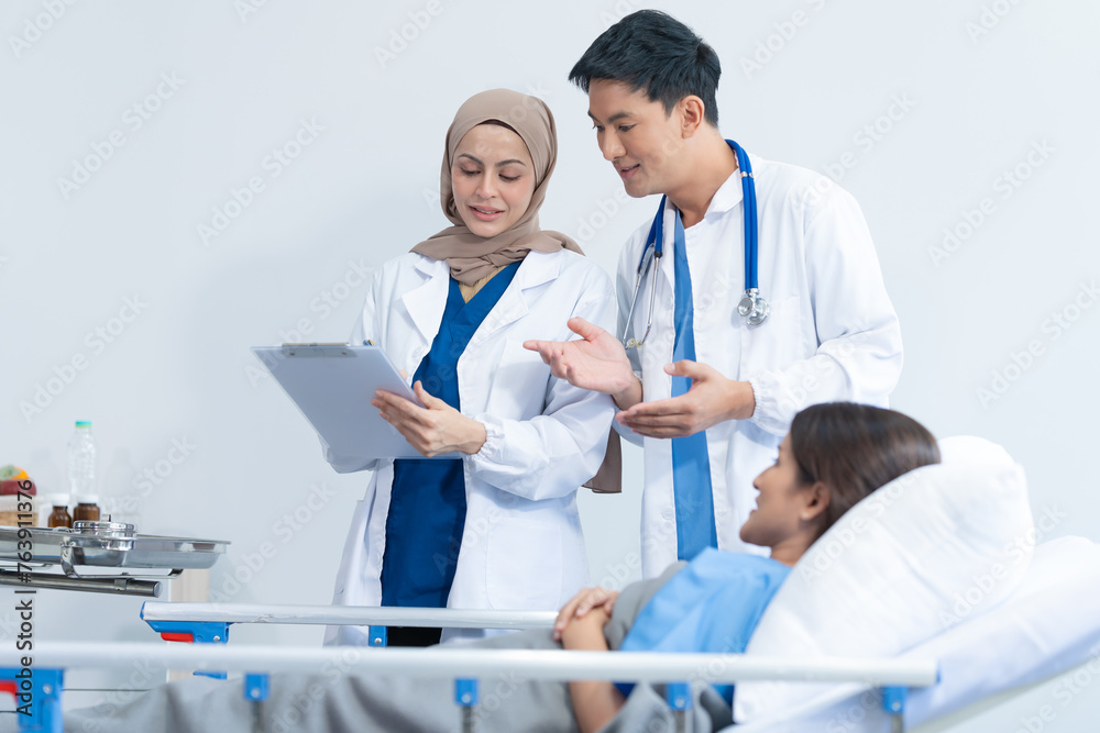 Obraz premium Two conficent doctor or specialist of kidney cancer talking together with female mix race patient on bed at medical ward, checkup, recovering after successful surgery concept.