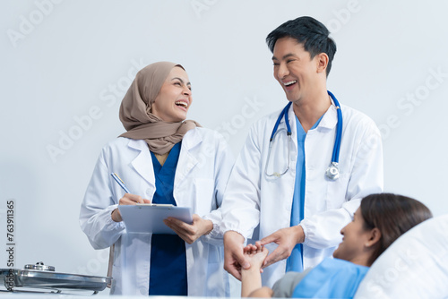 Two conficent doctor or specialist of kidney cancer talking together with female mix race patient on bed at medical ward  checkup  recovering after successful surgery concept.