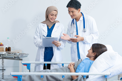 Two conficent doctor or specialist of kidney cancer talking together with female mix race patient on bed at medical ward  checkup  recovering after successful surgery concept.