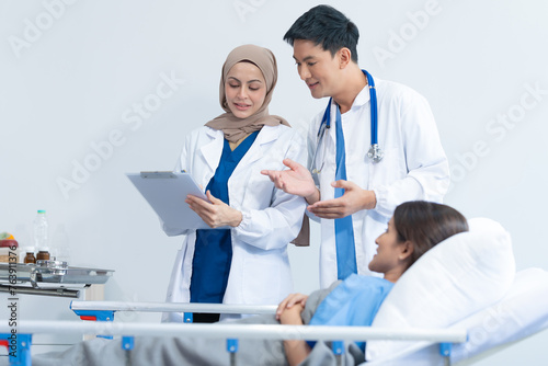 Two conficent doctor or specialist of kidney cancer talking together with female mix race patient on bed at medical ward, checkup, recovering after successful surgery concept.
