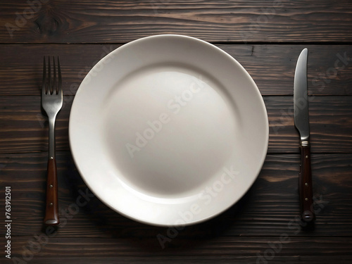 rustic wooden table and an empty white plate with fork and knife on the sides