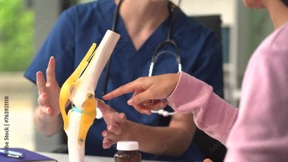 Knee model showing the process of osteoarthritis and knee arthroplasty, doctors explaining