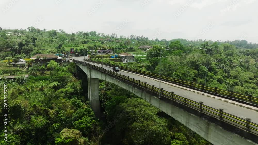 A car drives along a beautiful bridge among the tropics on the island of Bali drone shot 4k A car drives along a beautiful bridge among the tropics on the island of Bali drone shot 4k