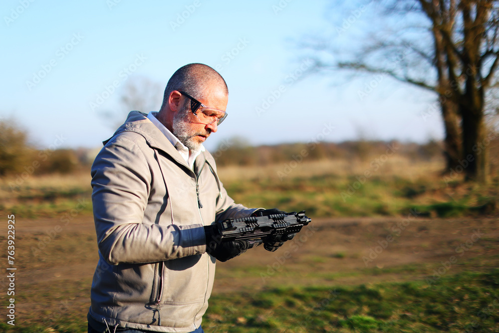 Man with gray jacket shooting black rifle on range Man with gray jacket shooting black rifle on range