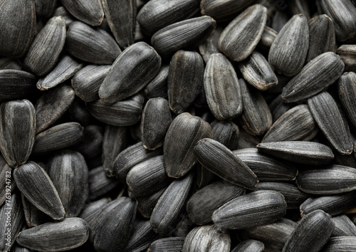 Raw dried black sunflower seeds top view macro background.Popular snack.