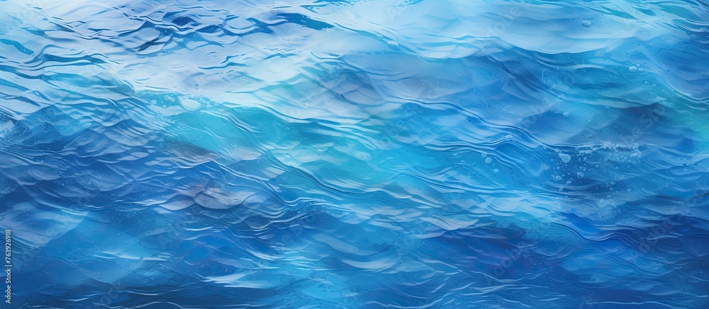 A detailed view of a fluid electric blue water surface with wind waves creating a mesmerizing pattern, under a cumulusfilled sky on the horizon