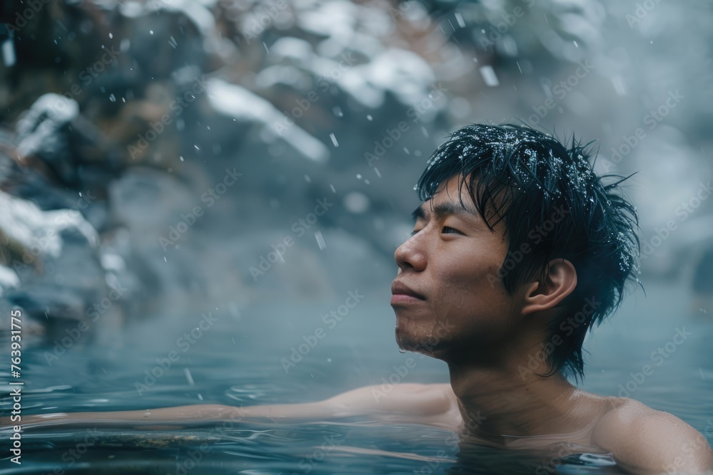 Fototapeta premium Asian man bathes in a hot thermal spring. Rest. Winter snow. relax