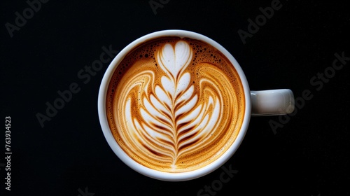 Exquisite top-down view of latte with perfect symmetrical leaf art on dark background