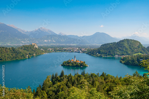 View of Lake Bled with St. Marys Church of Assumption on a small island on a sunny day. Lake with turquoise water. Slovenia  Europe. Mountains on background. Areal view from above.