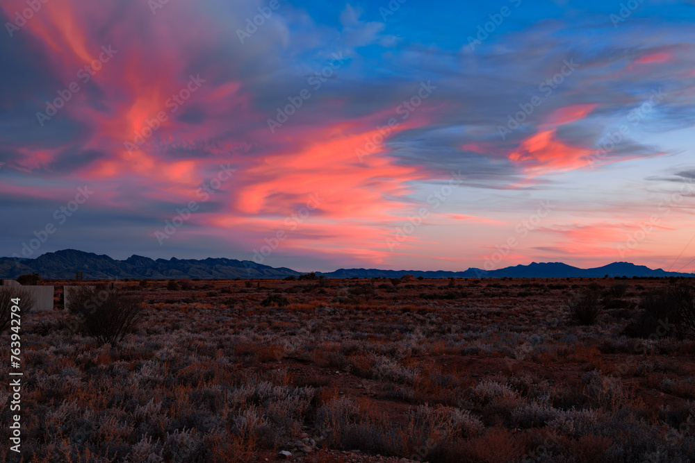 Crimson Sky Over Desert Terrain