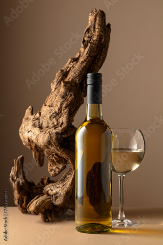 White wine and old snag on a beige background. photo