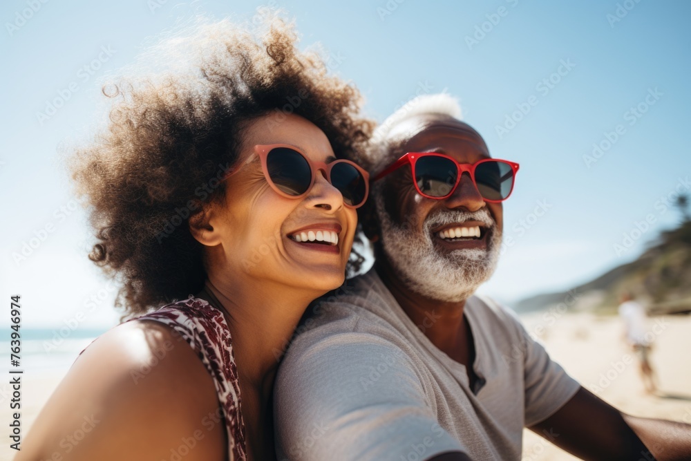 Happy senior couple with sunglasses at beach.