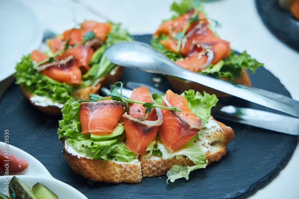 Sandwiches with red fish on the festive table.