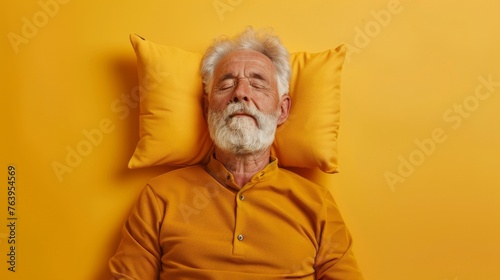 Elderly man sleeping on pillow isolated on pastel yellow colored background Sleep deeply peacefully rest. Top above high angle view photo portrait of satisfied .senior wear yellow shirt