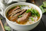 bowl of pho with beef slices, garnished with herbs