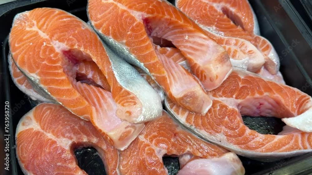 Atlantic salmon steaks from frozen raw materials on a substrate for sale in the supermarket. Close-up Atlantic salmon steaks from frozen raw materials on a substrate for sale in the supermarket. Close-up