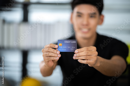 Young seller man look intend holding looking at camera to present product via live online for shopping online with e-commerce sell, Asian blogger showing goods in front of camera recording vlog video