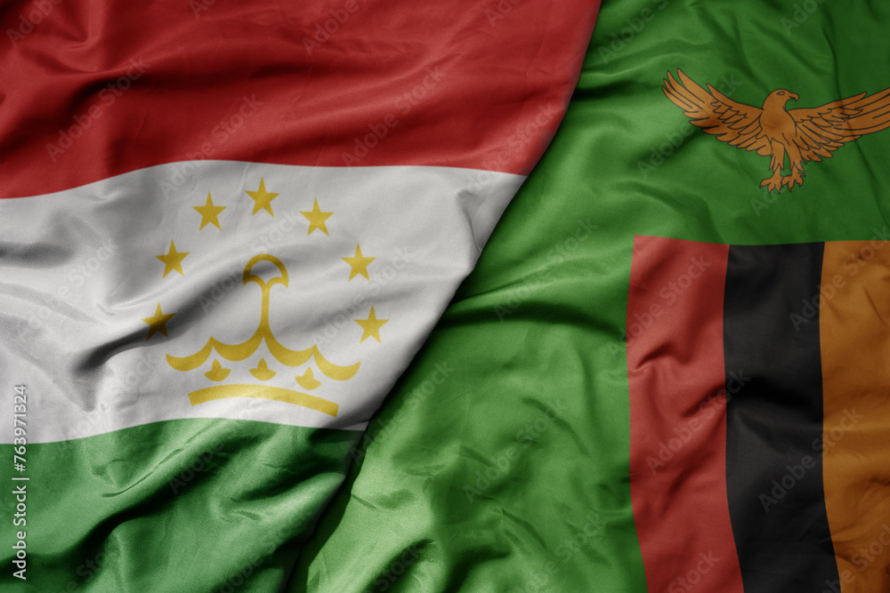 big waving national colorful flag of zambia and national flag of tajikistan. big waving national colorful flag of zambia and national flag of tajikistan.